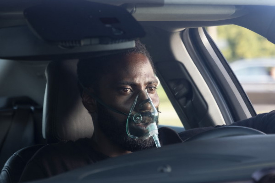 Protagonist filma z masko na obrazu v avtu.